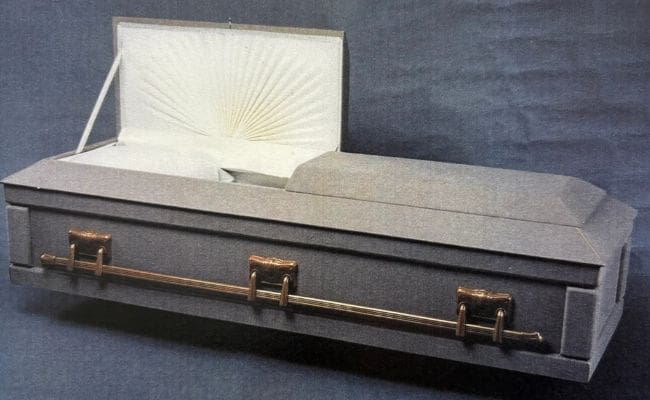 Closed beige coffin with decorative interior lid.
