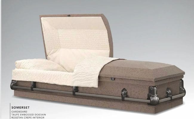 A brown and beige casket with a padded interior and headrest.