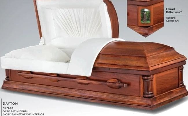 Elegant wooden coffin with white interior lining and handles.